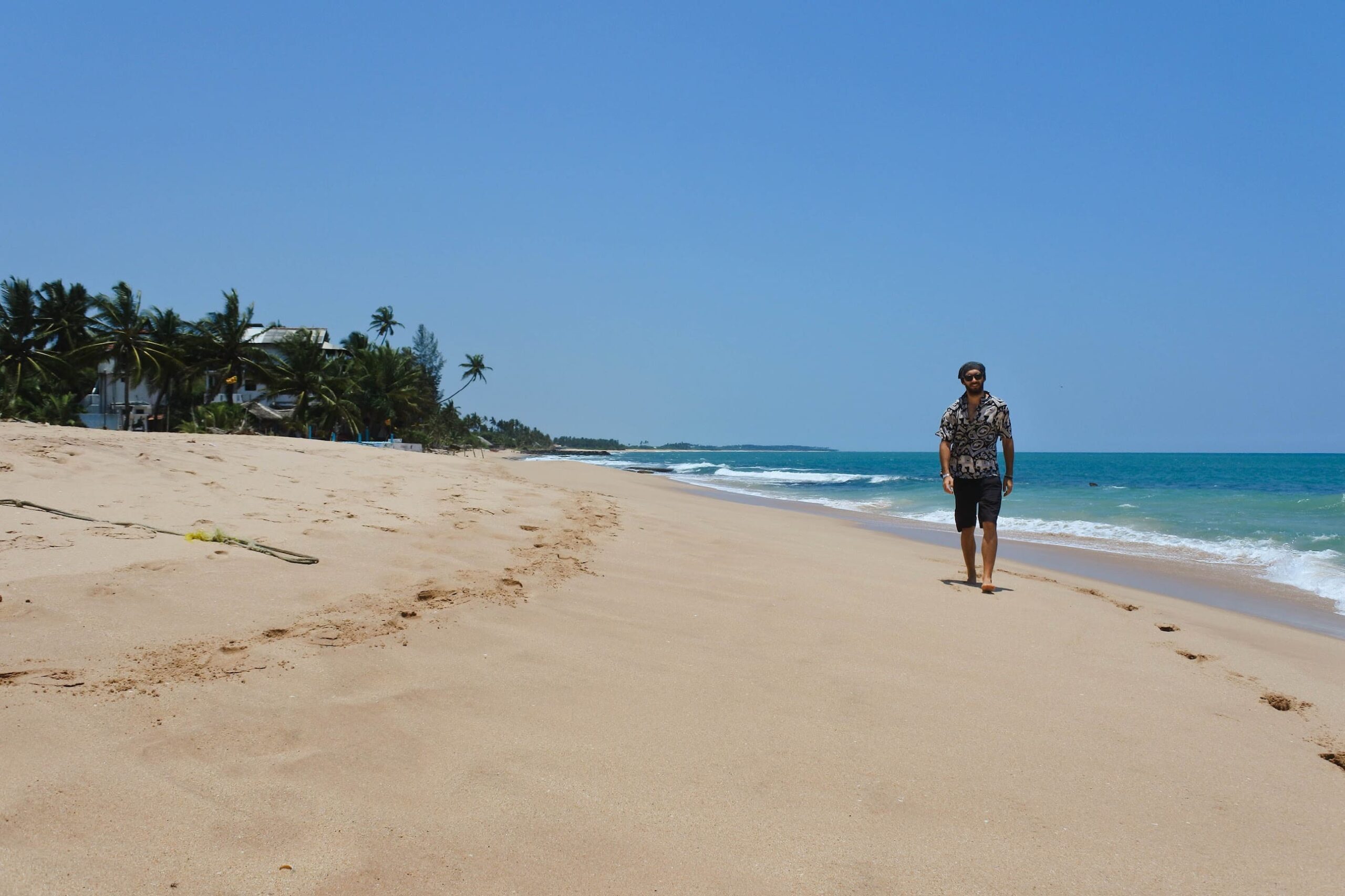 Quiet beach in Tangalle with palm trees and ocean waves