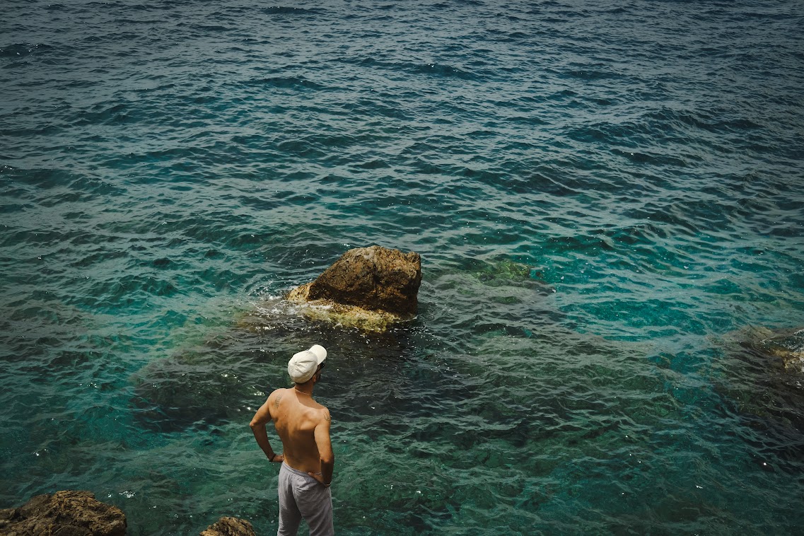 a man model shirtless standing by the sea